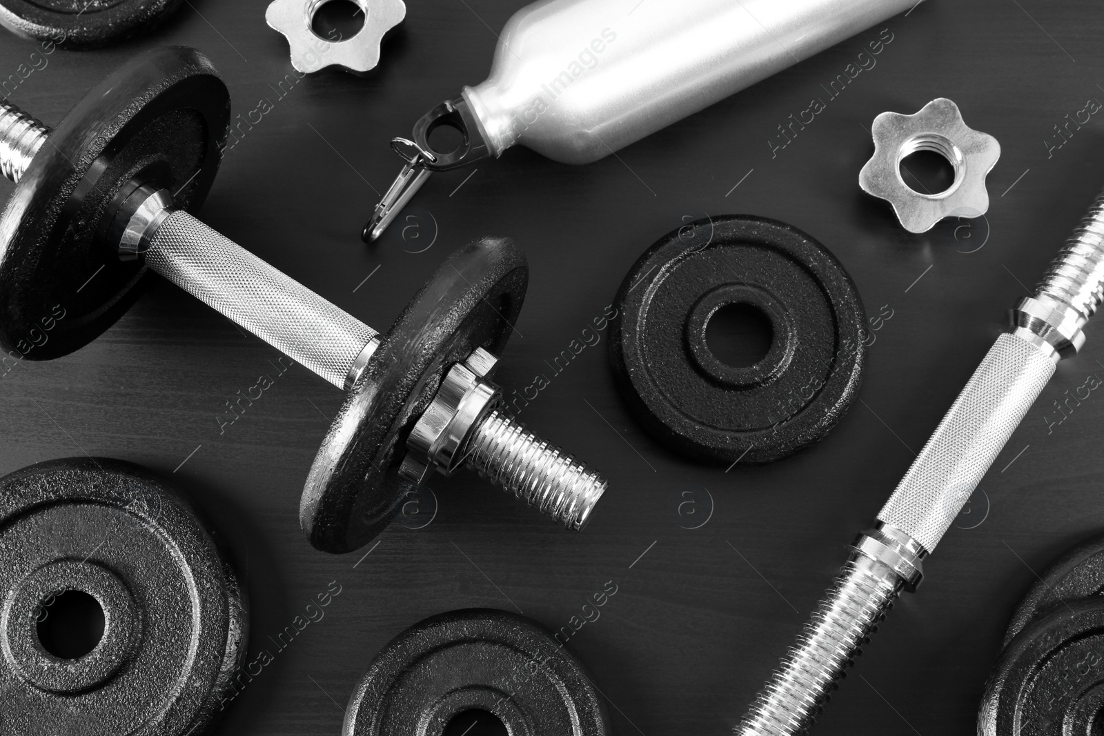 Photo of Flat lay composition with dumbbell and parts on dark wooden background