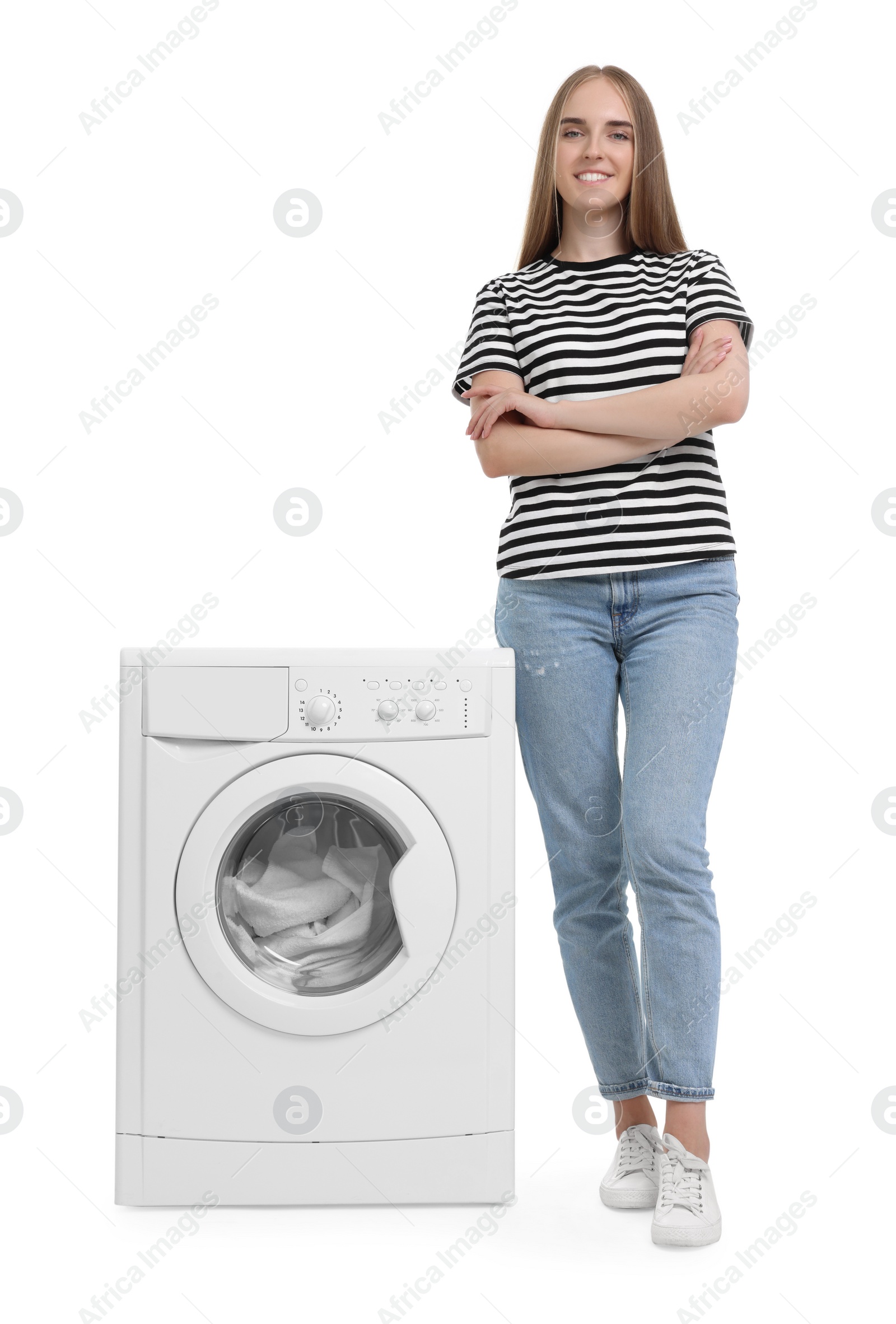 Photo of Beautiful young woman near washing machine with laundry on white background