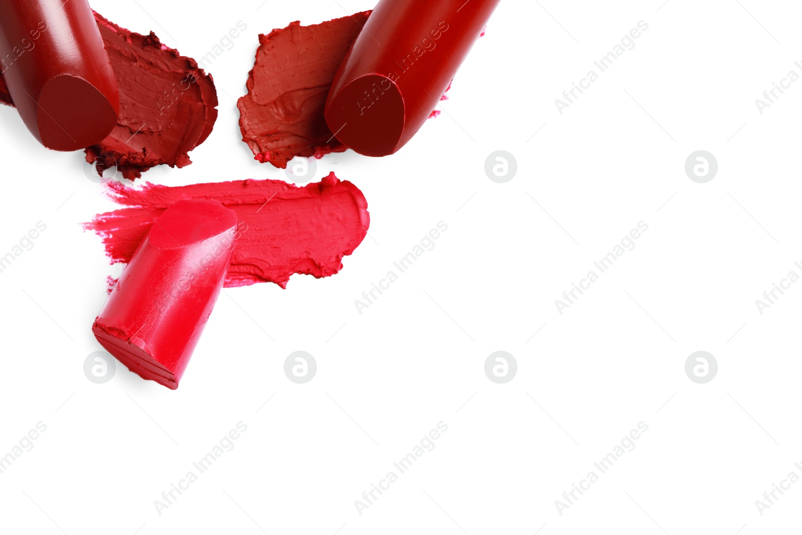 Photo of Different lipsticks and smears on white background, top view