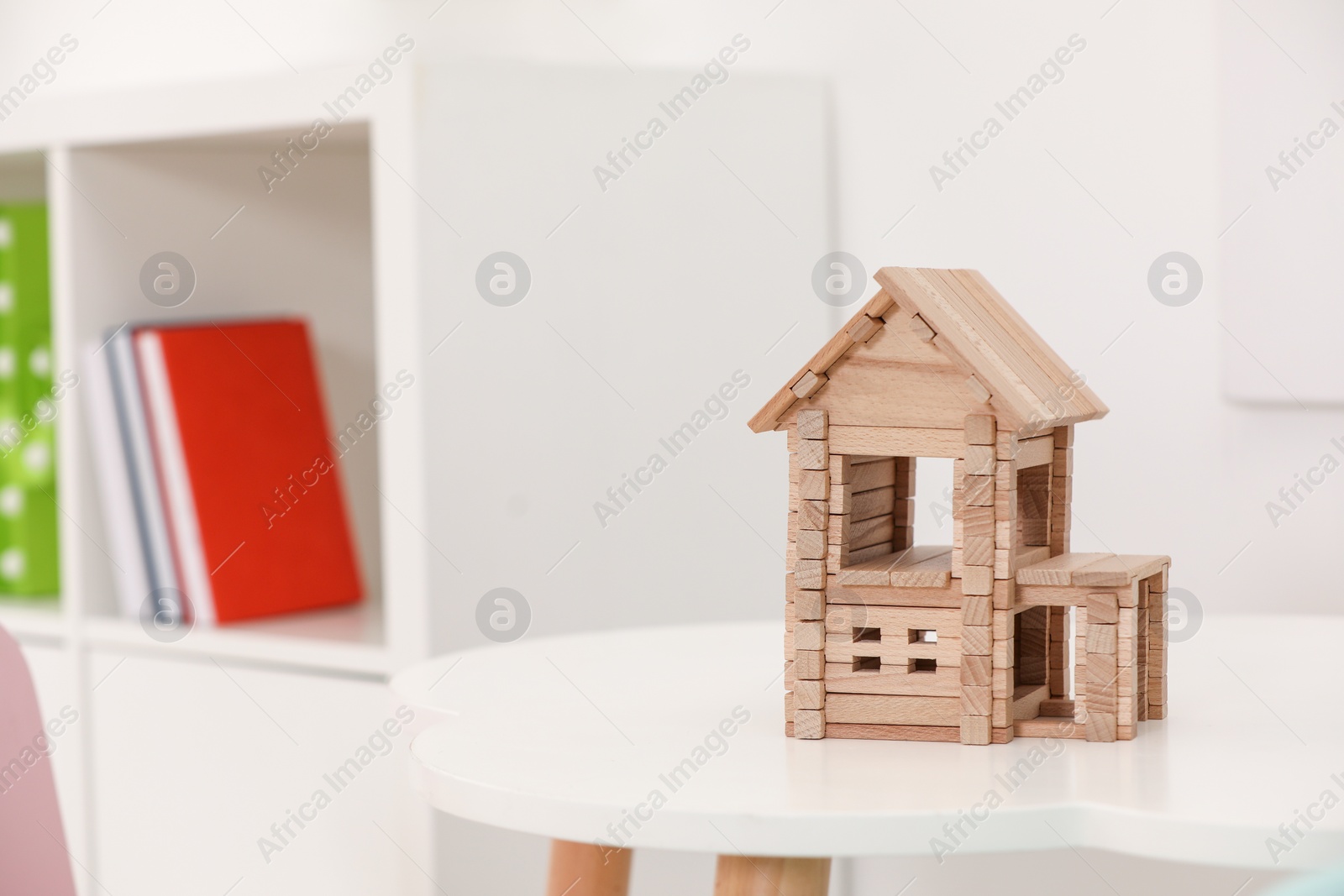 Photo of Wooden house on white table indoors, space for text. Children's toy