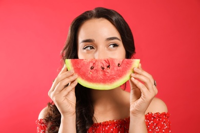 Beautiful young woman with watermelon on red background