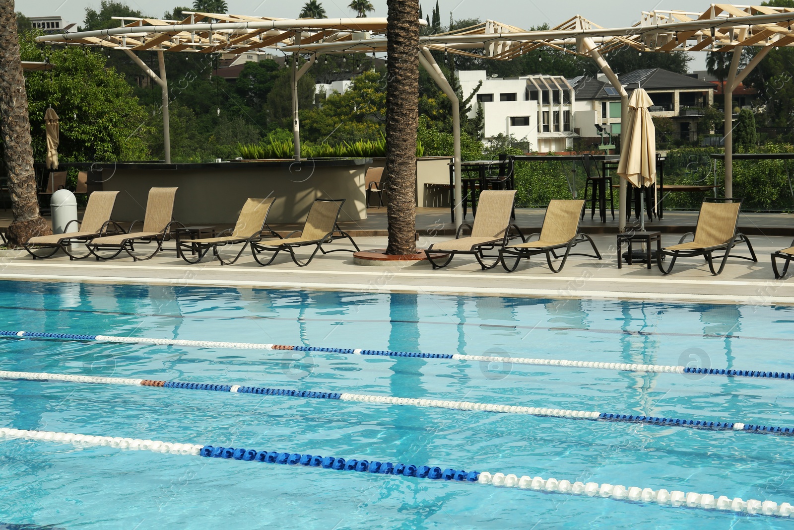 Photo of Swimming pool and sunbeds at luxury resort