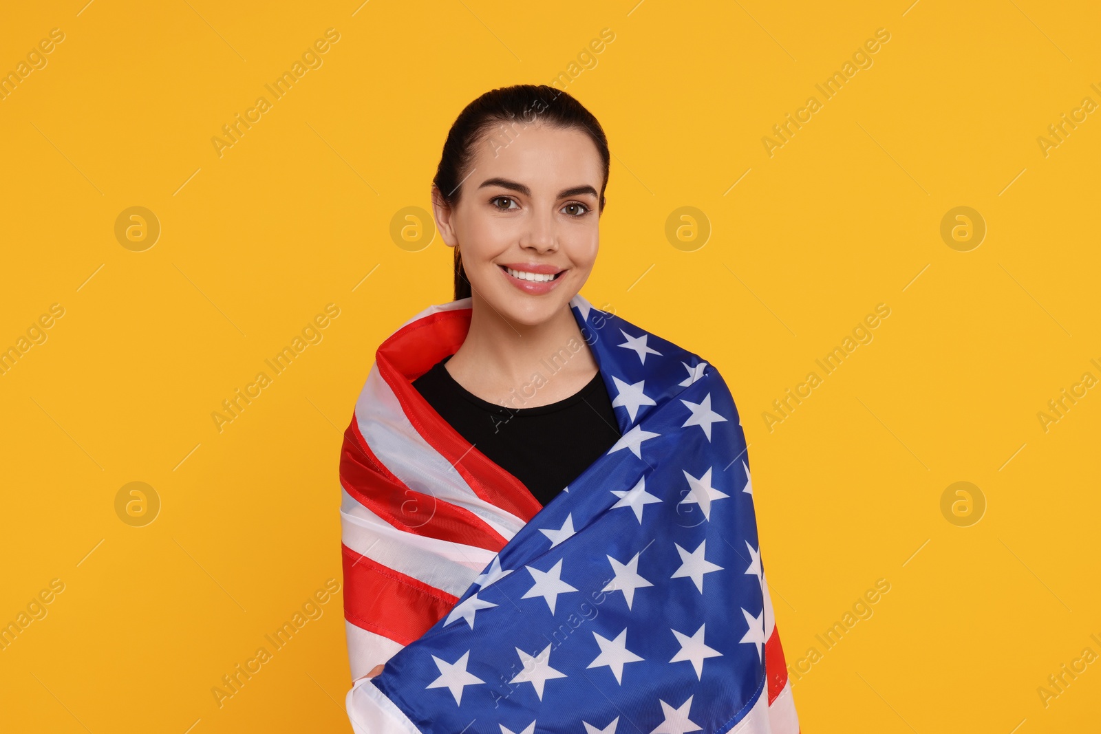 Photo of 4th of July - Independence Day of USA. Happy woman with American flag on yellow background