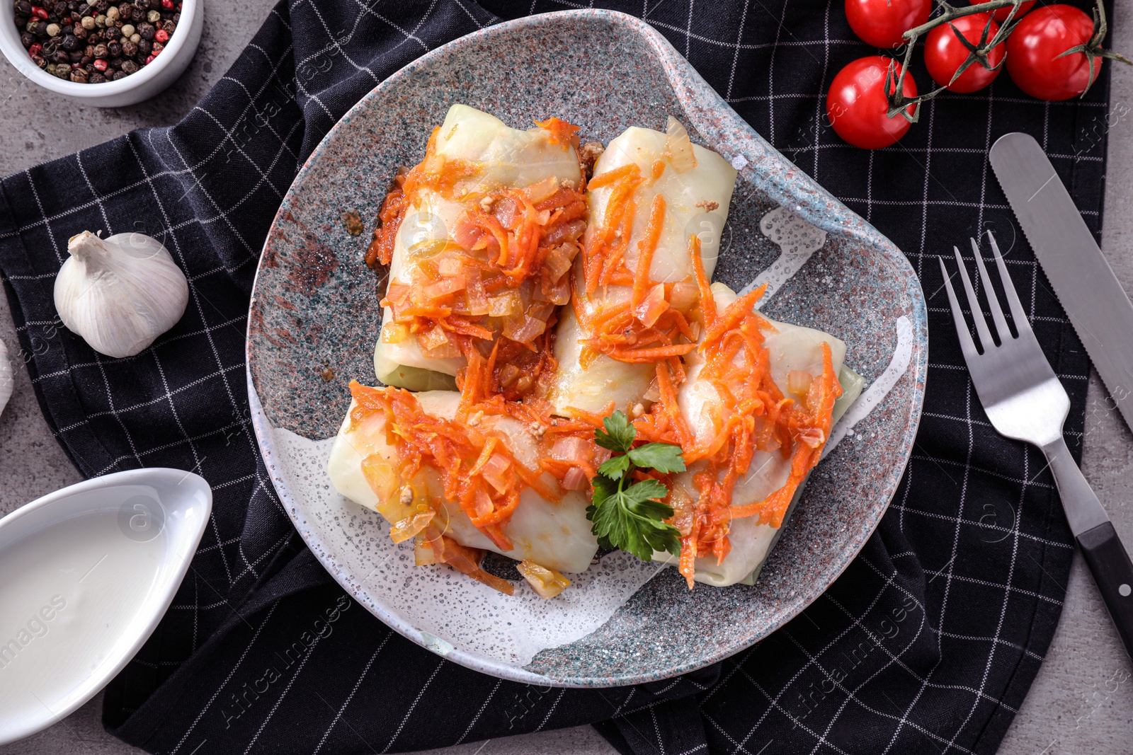 Photo of Delicious cabbage rolls served on grey table, flat lay