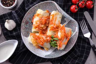 Photo of Delicious cabbage rolls served on grey table, flat lay