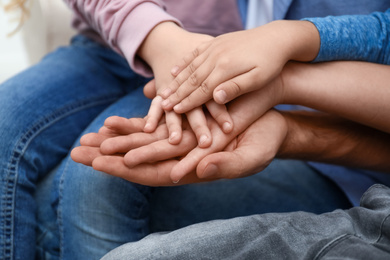 Photo of Closeup view of happy family holding hands