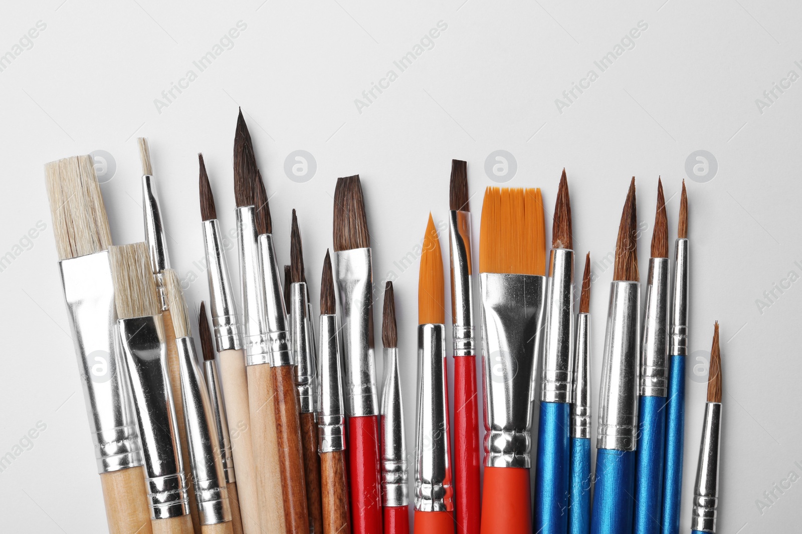 Photo of Different paint brushes on white background, top view