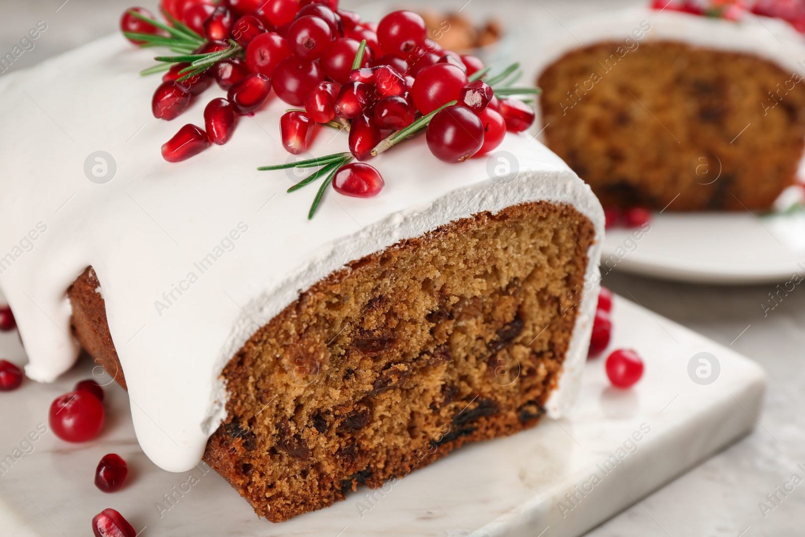 Photo of Traditional classic Christmas cake decorated with cranberries, pomegranate seeds and rosemary on table, closeup
