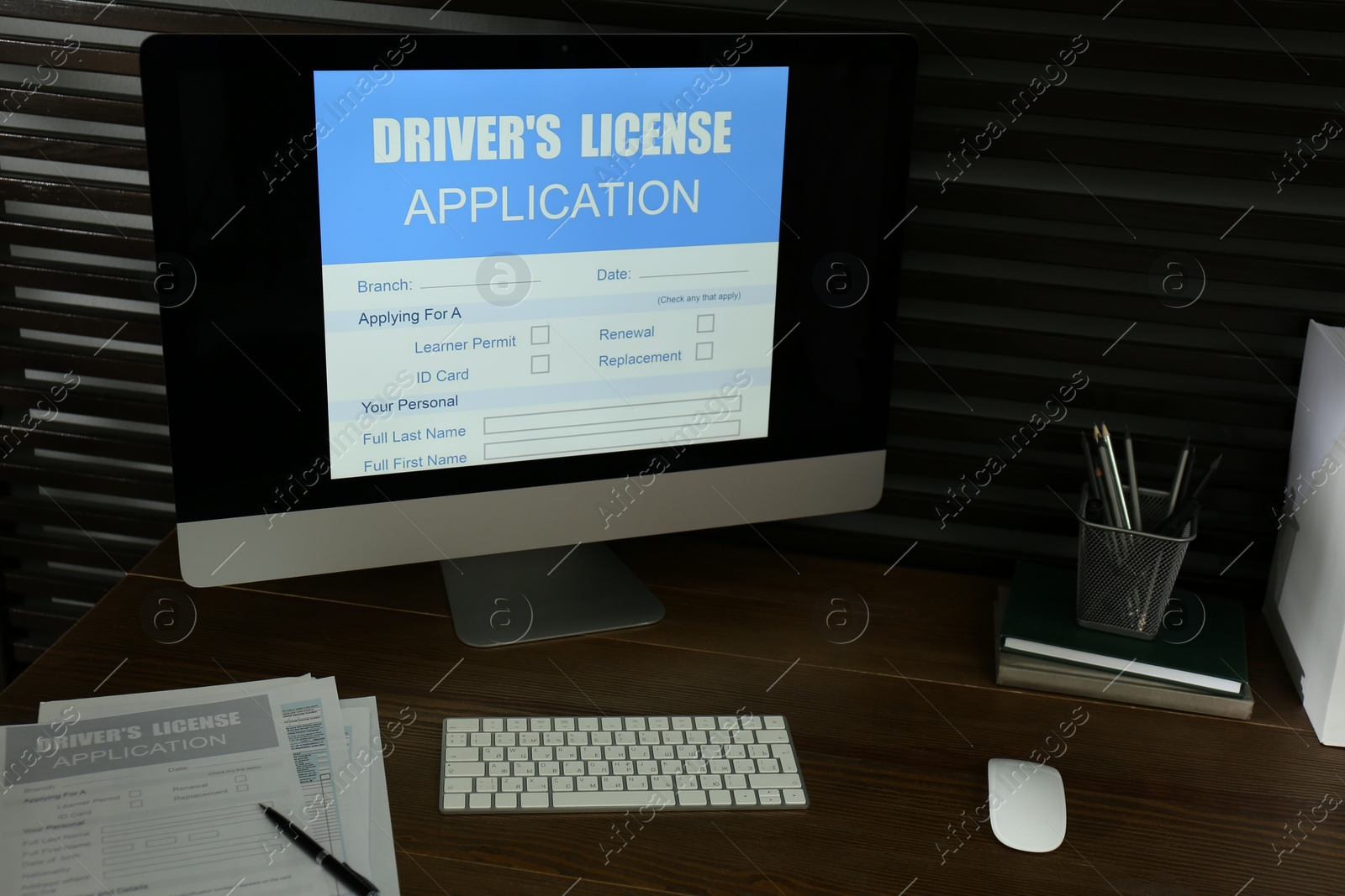 Photo of Computer with driver's license application form on table in office