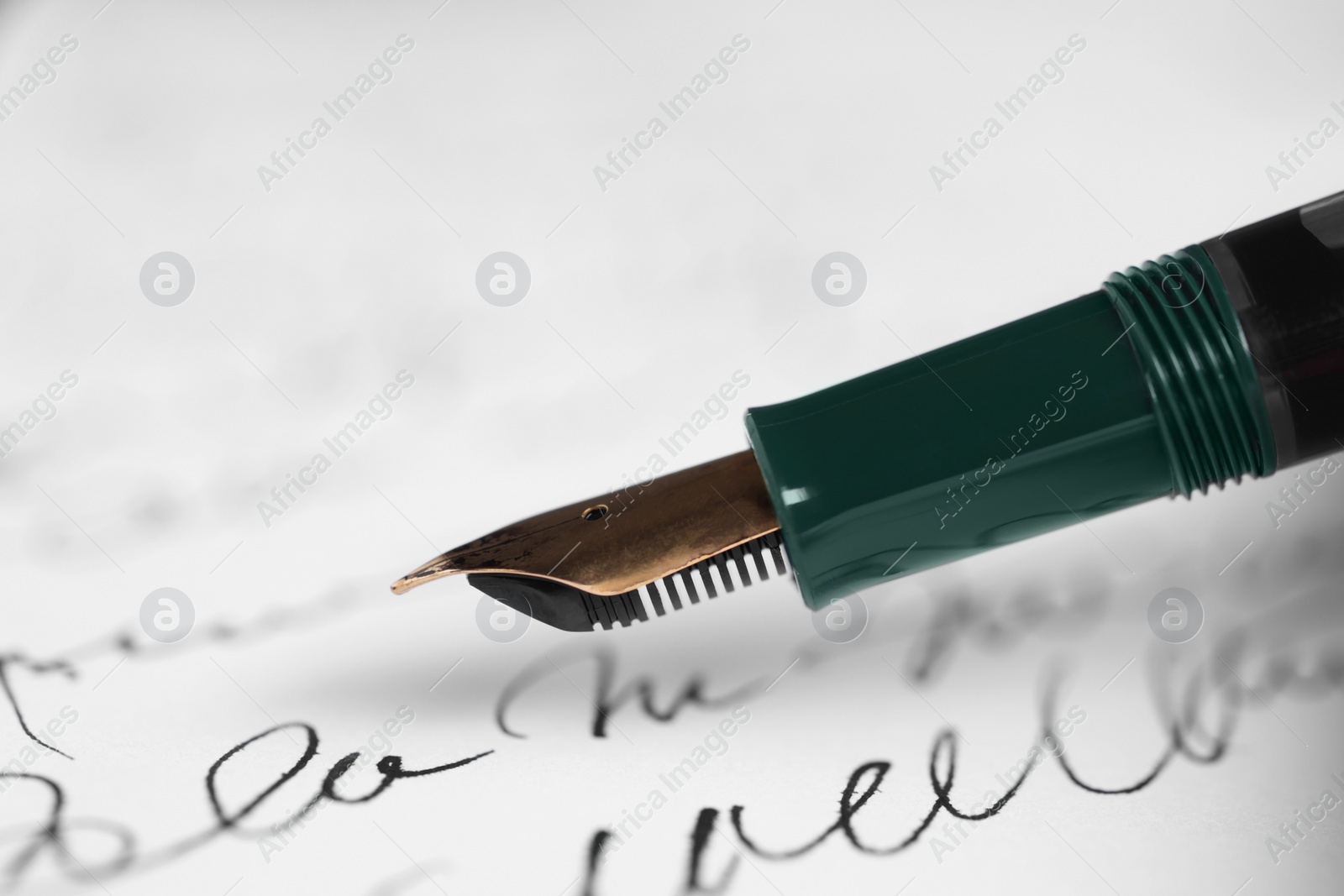 Photo of Elegant fountain pen on handwritten letter, closeup