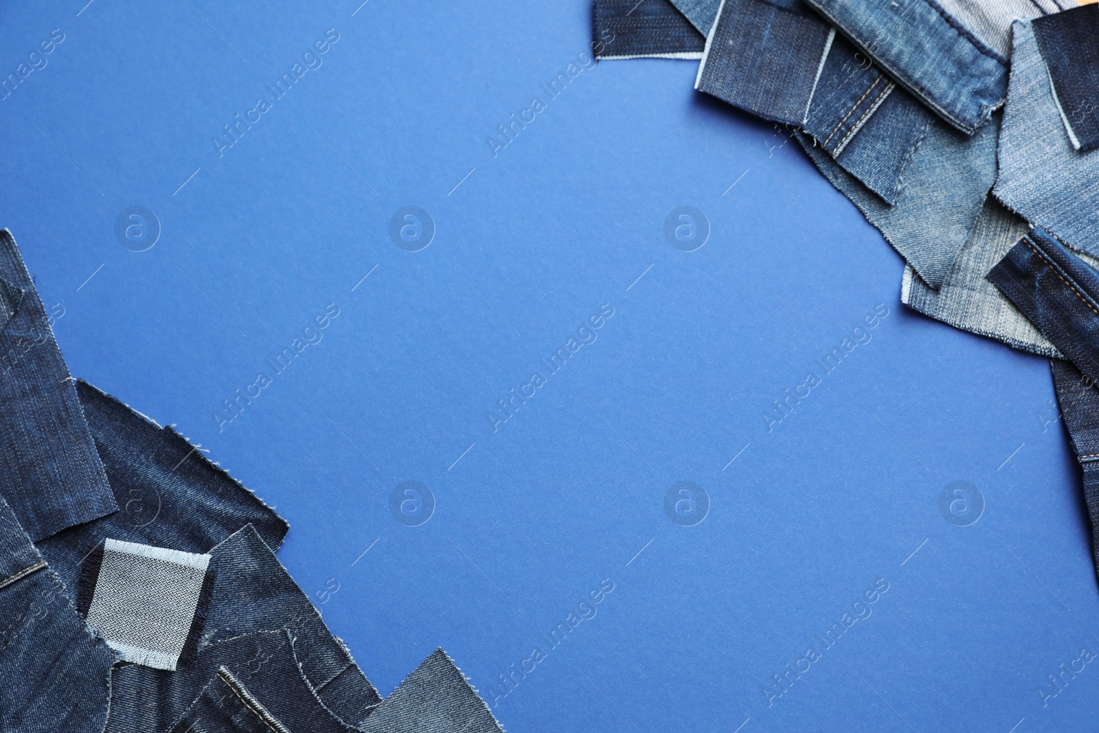 Photo of Frame made of cut jeans on blue background, top view. Space for text