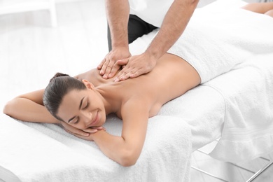 Relaxed woman receiving back massage in wellness center