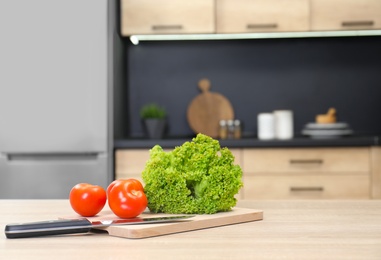 Fresh vegetables on wooden table in kitchen. Space for text