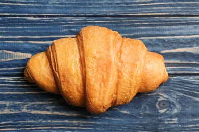 Tasty croissant on wooden background, top view