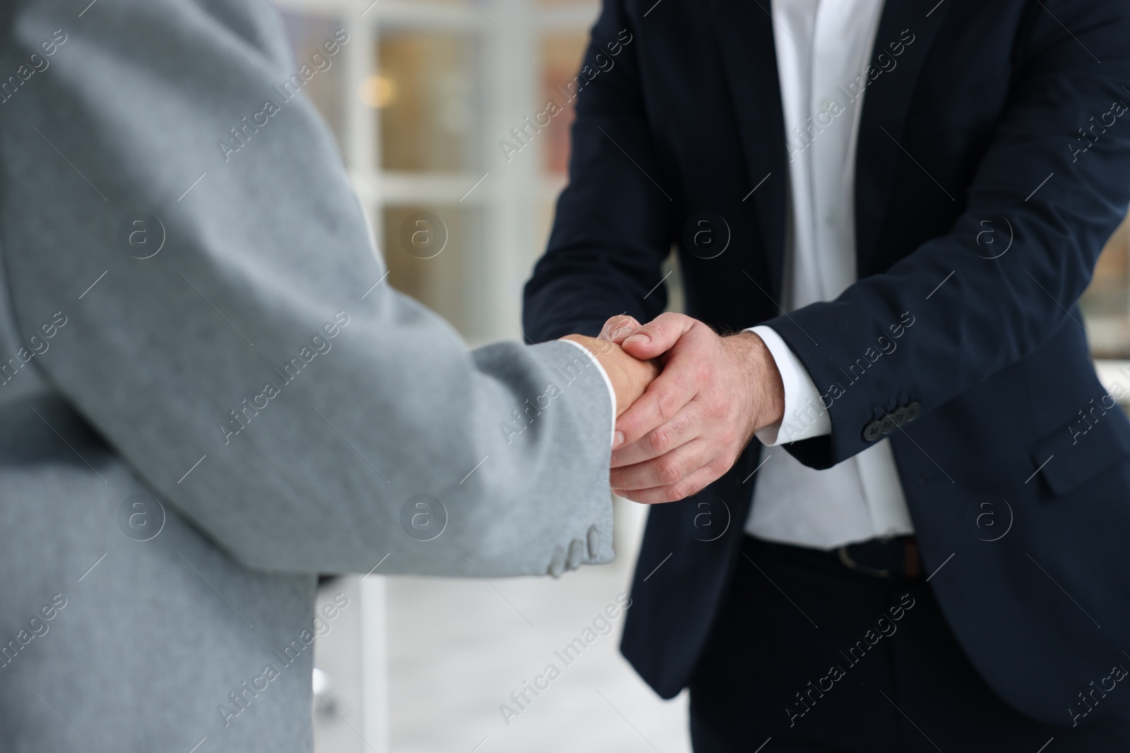 Photo of Lawyer shaking hands with client in office, closeup