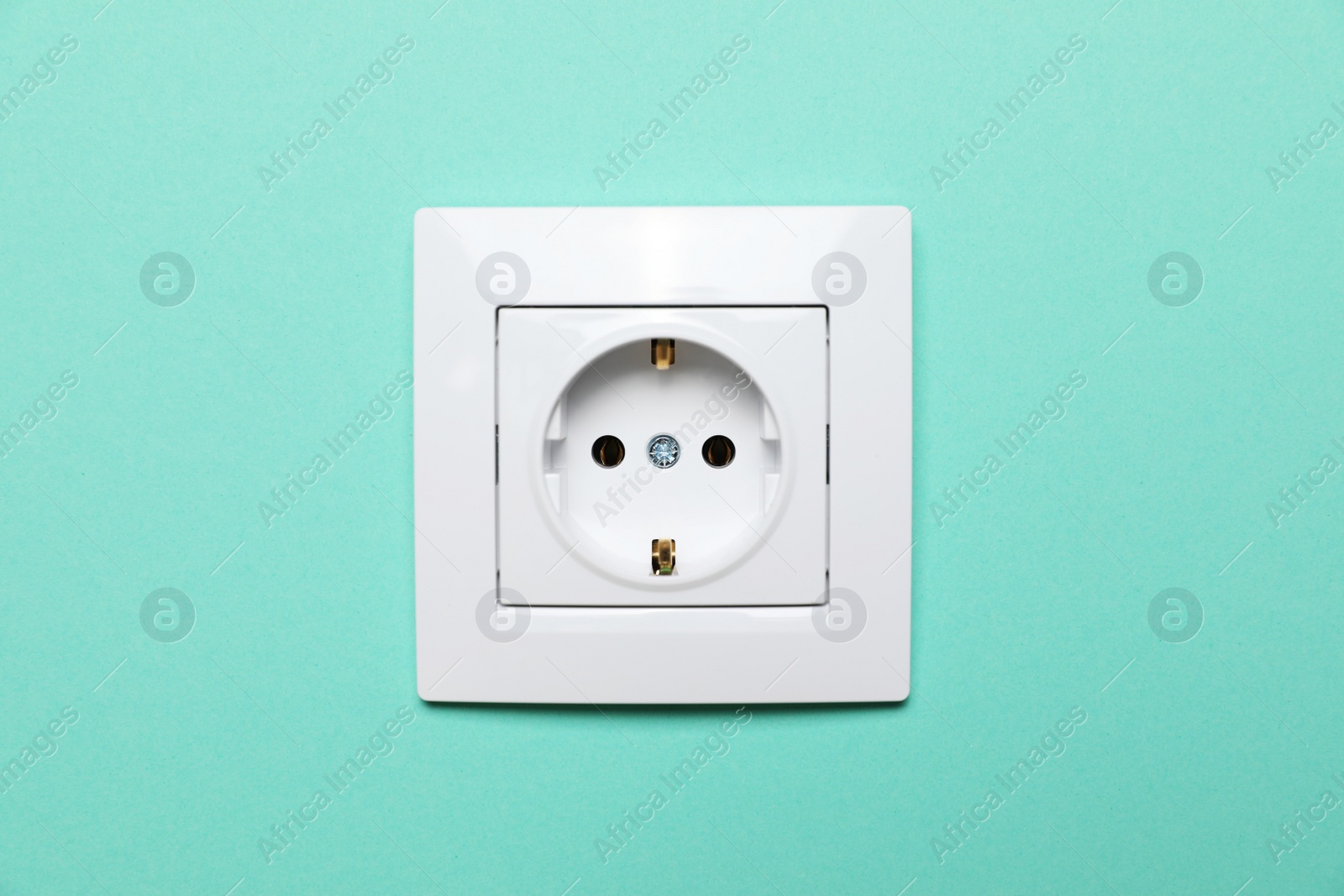 Photo of Power socket on turquoise wall. Electrical supply