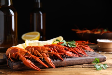 Photo of Delicious red boiled crayfishes on wooden table