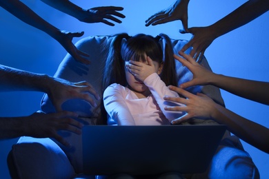 Photo of Strangers reaching frightened little child with laptop on color background. Cyber danger