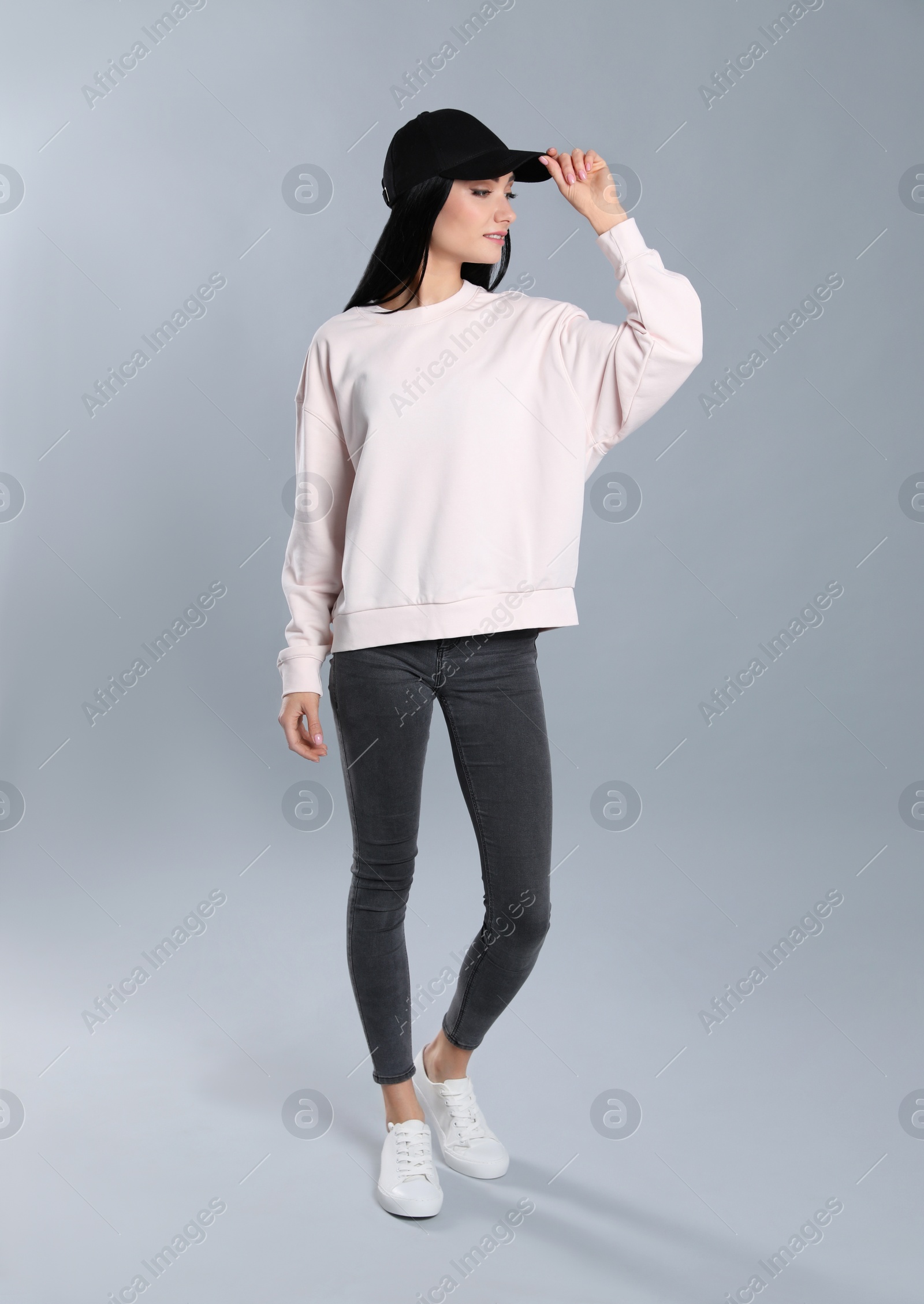 Photo of Full length portrait of young woman in sweater on grey background. Mock up for design