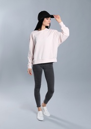 Full length portrait of young woman in sweater on grey background. Mock up for design