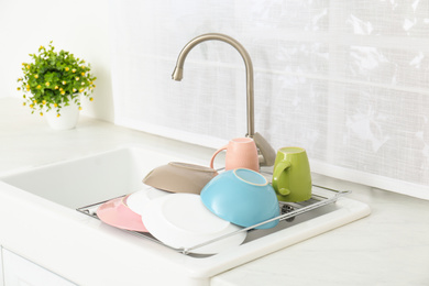 Drying rack with clean dishes over sink in kitchen