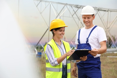 Professional engineers working on installation of electrical substation outdoors