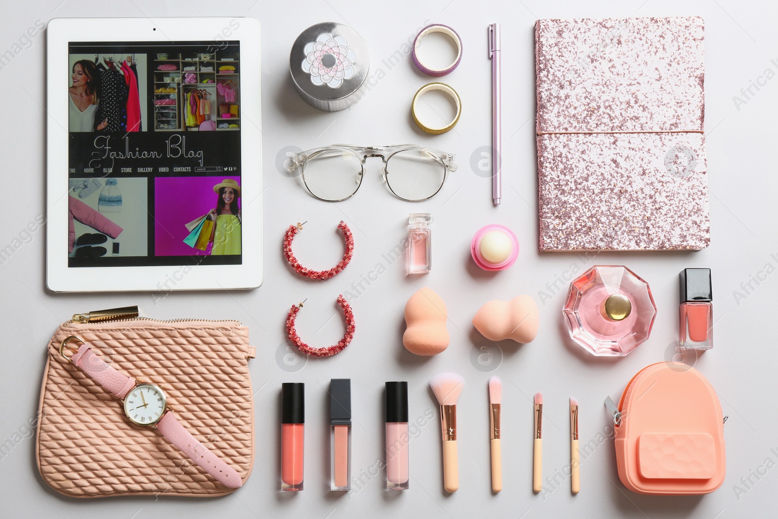 Photo of Flat lay composition with tablet, makeup products and accessories on light background. Fashion blogger