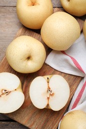 Photo of Cut and whole apple pears on wooden table, flat lay