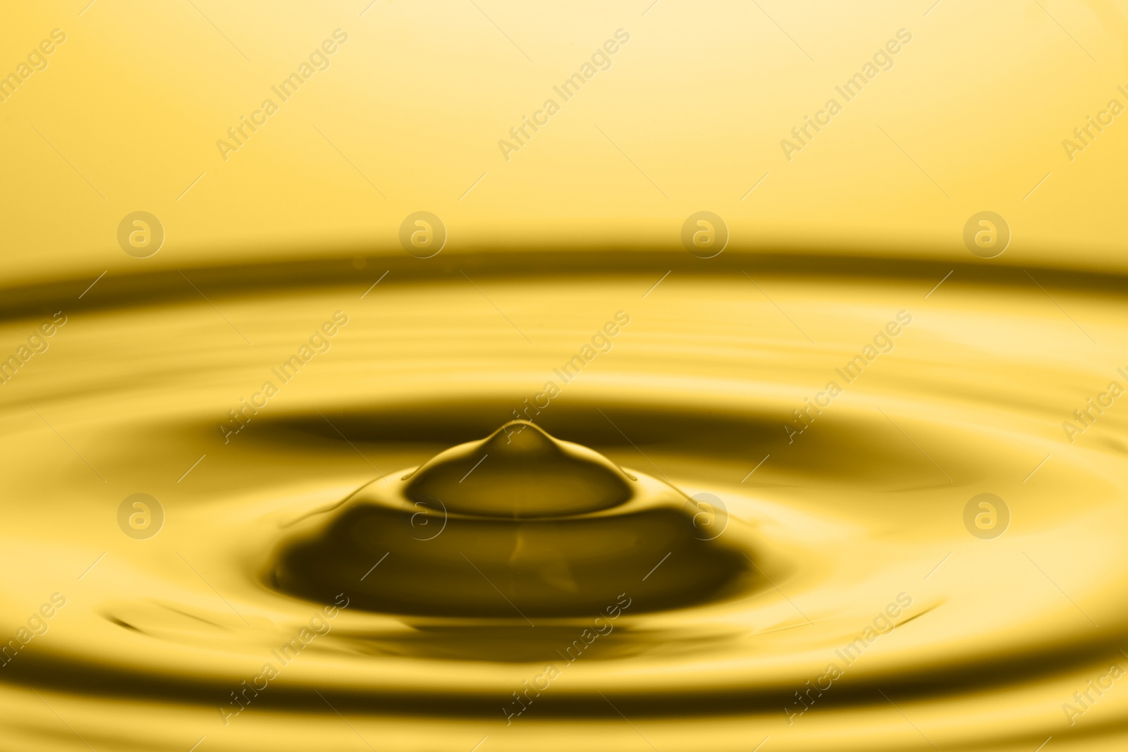 Image of Splash of golden oily liquid as background, closeup