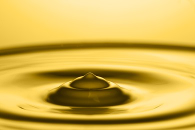 Splash of golden oily liquid as background, closeup