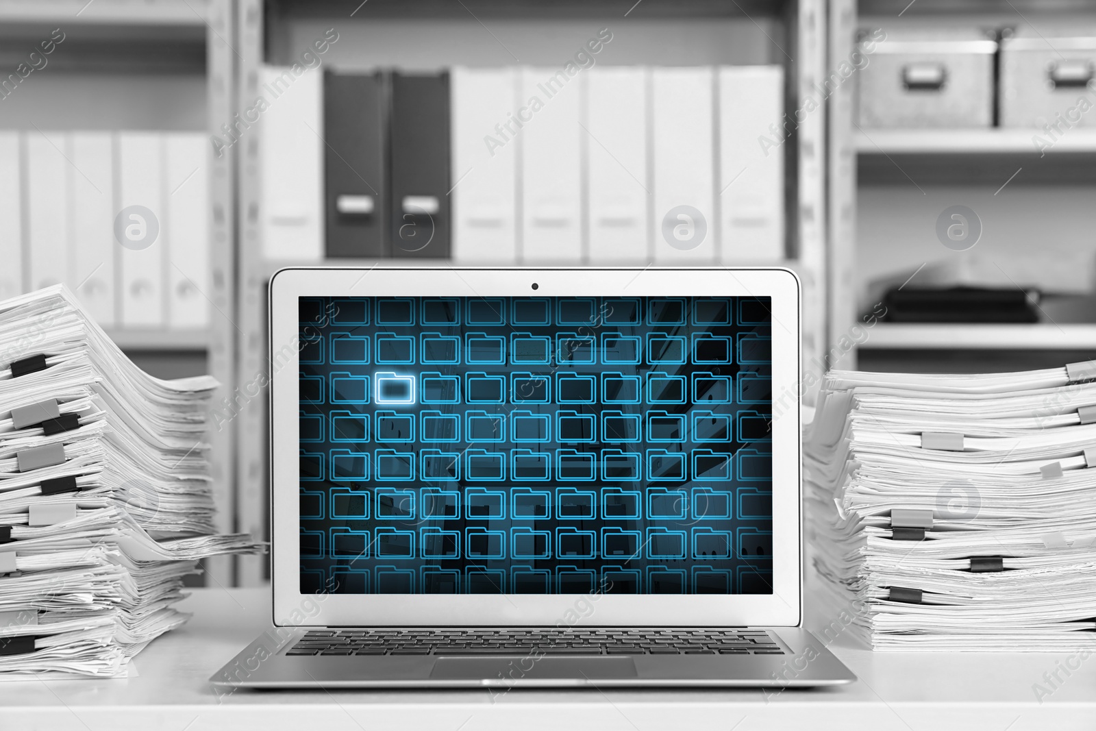 Image of Laptop with digital archive program in office. Many folder icons and one highlighted on display