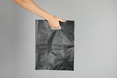 Photo of Woman with plastic bag on grey background. Mock up for design