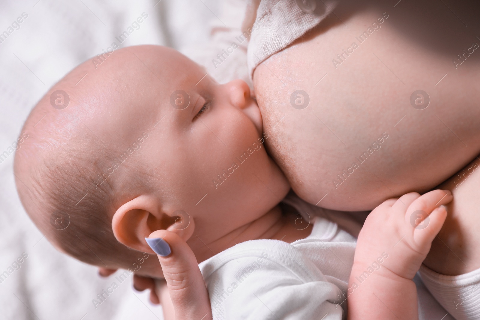 Photo of Mother breastfeeding her newborn baby, closeup view