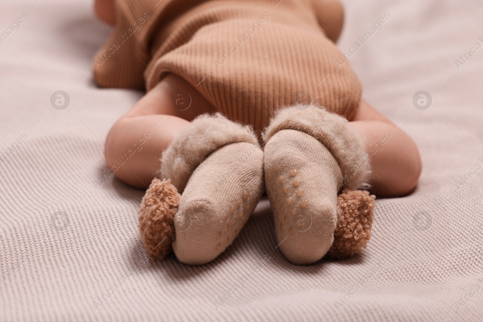 Photo of Newborn baby lying on brown blanket, closeup