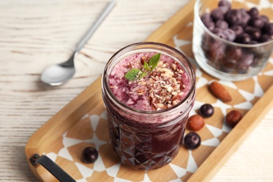 Photo of Mason jar of delicious acai juice on wooden table