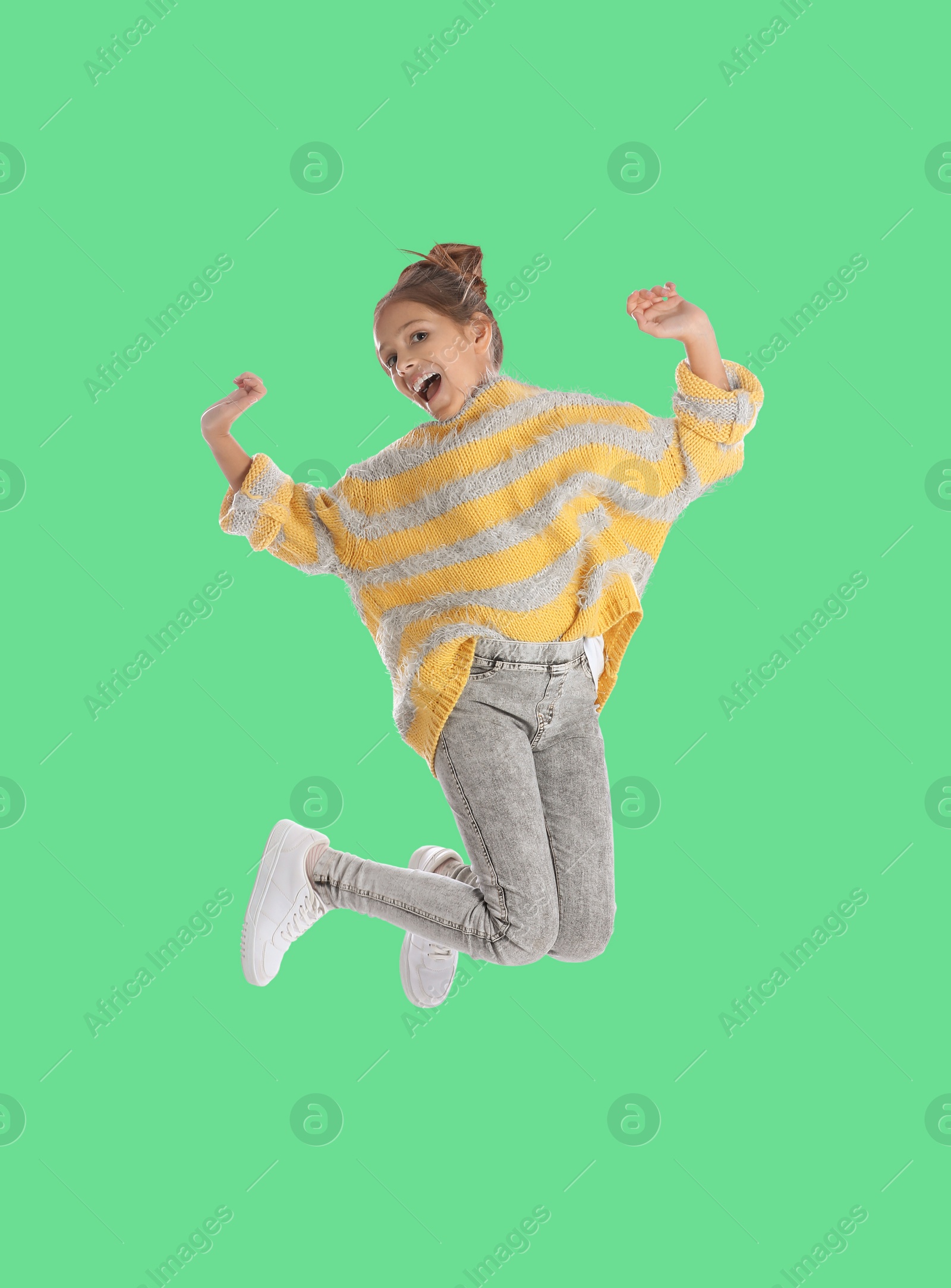 Image of Happy cute girl jumping on green background