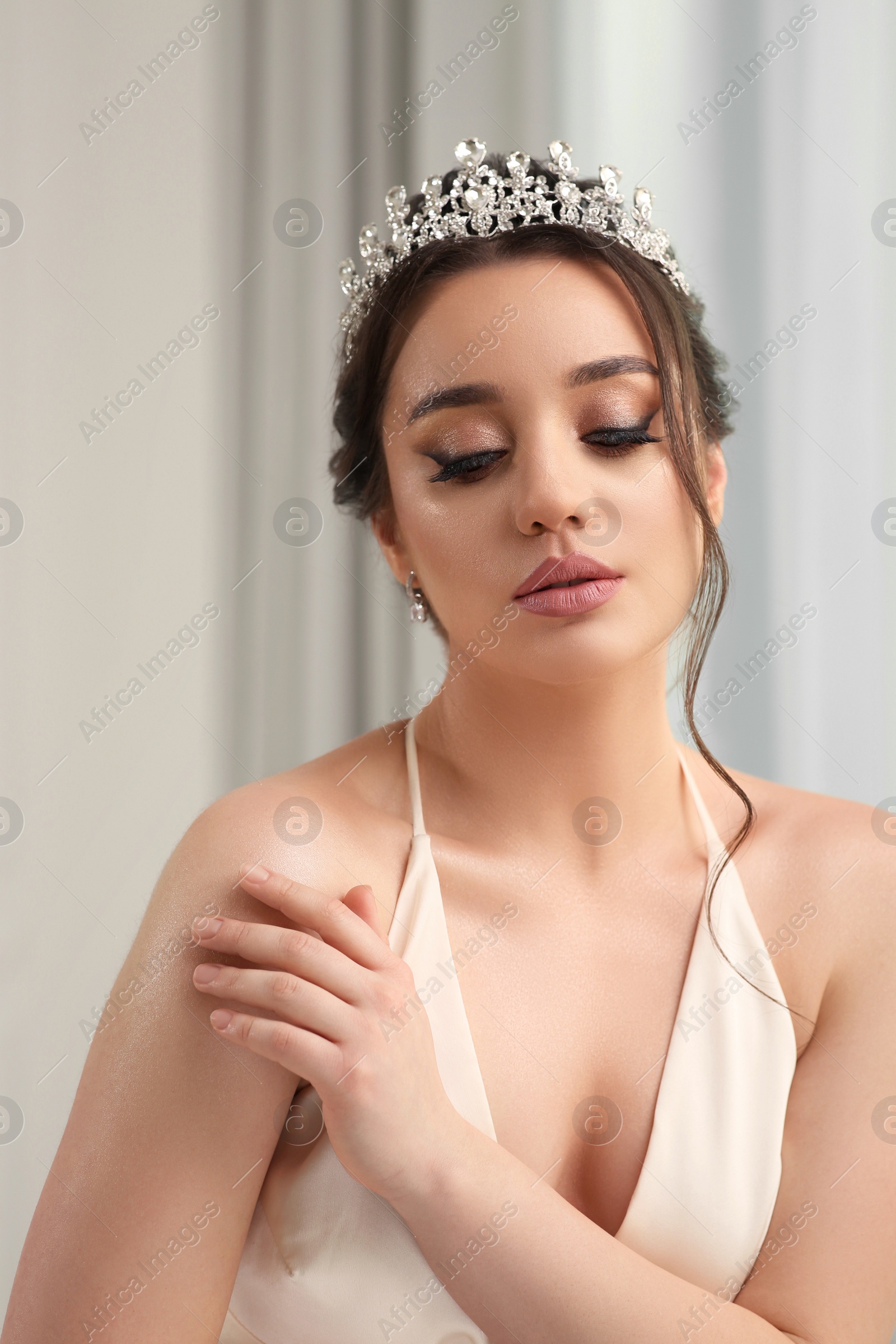 Photo of Beautiful young woman wearing luxurious tiara indoors