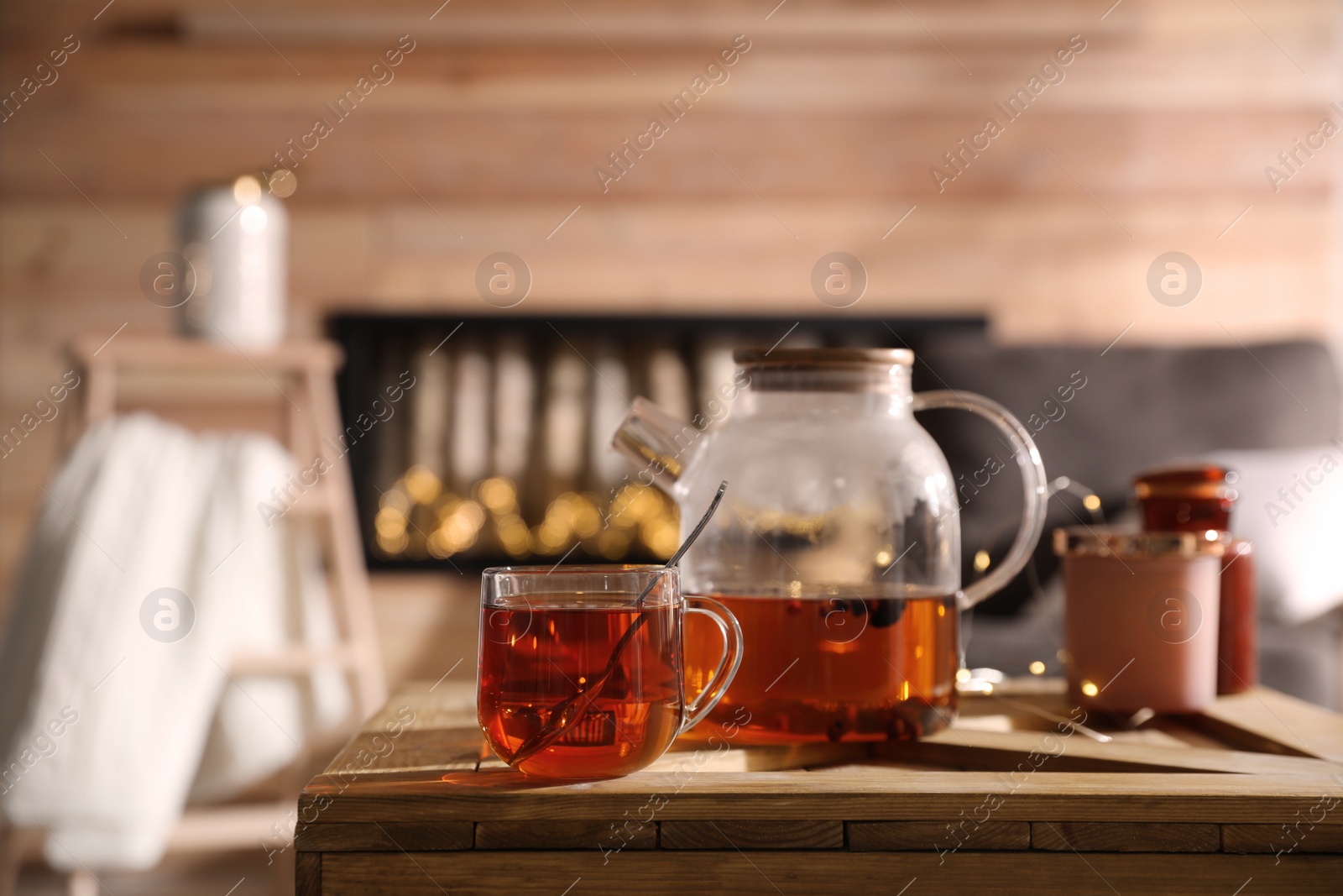 Photo of Teapot and cup with hot tea on table indoors