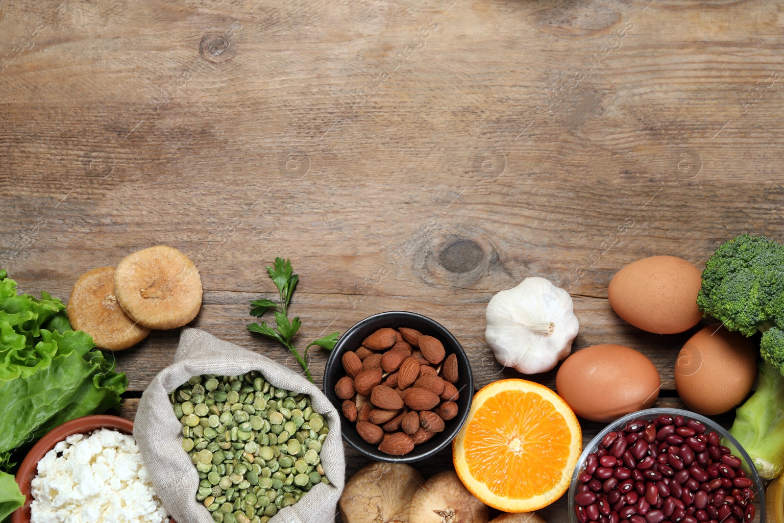 Photo of Set of natural food high in calcium on wooden table, flat lay. Space for text