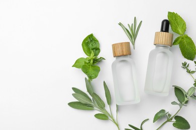Photo of Bottles of essential oil and fresh herbs on white background, flat lay. Space for text
