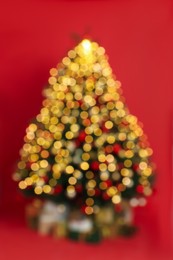Photo of Blurred view of beautifully decorated Christmas tree on red background