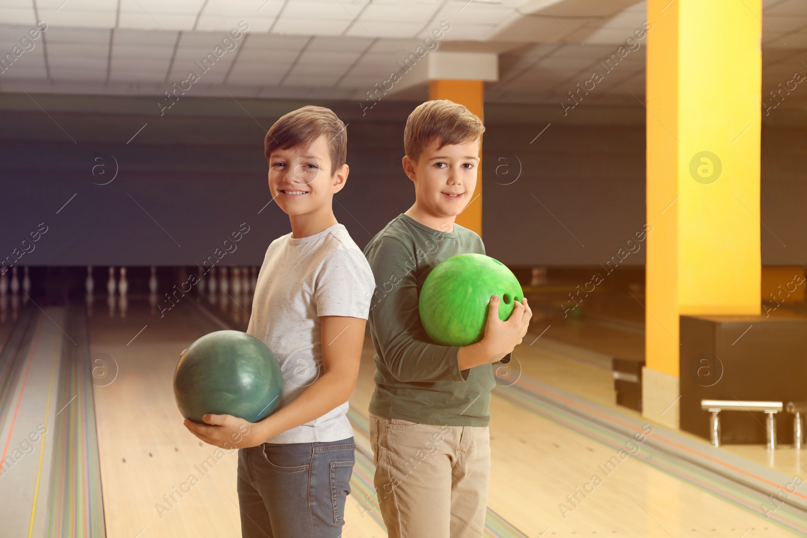 Photo of Happy boys with balls in bowling club