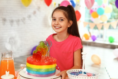 Photo of Happy girl in room decorated for birthday party