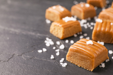 Photo of Salted caramel on grey table, closeup. Space for text