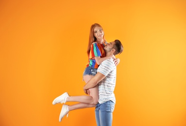 Photo of Young woman wearing shorts and man in stylish jeans on color background