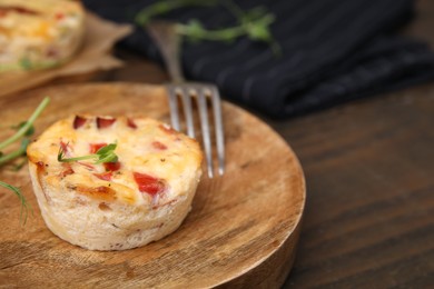 Photo of Delicious egg muffin with cheese and bacon on wooden table, closeup. Space for text