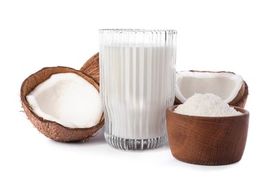 Glass of delicious vegan milk, coconuts and flakes on white background