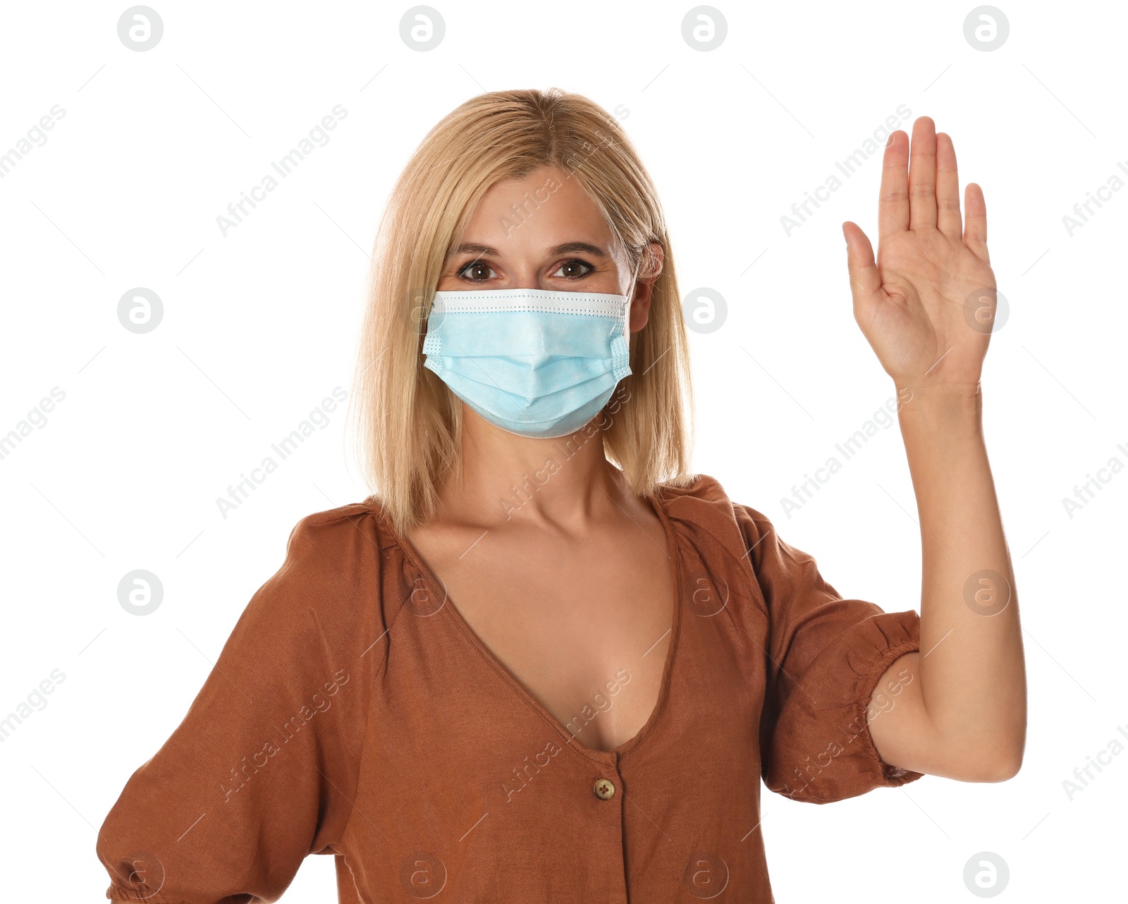 Photo of Woman in protective mask showing hello gesture on white background. Keeping social distance during coronavirus pandemic