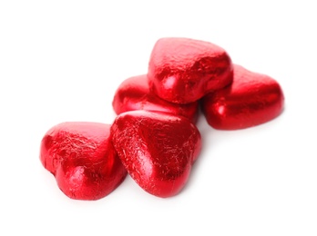 Heart shaped chocolate candies in red foil on white background