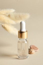 Composition with bottle of cosmetic serum on beige background